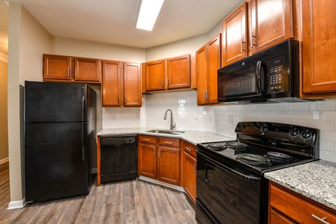 a kitchen with black appliances and wooden cabinets